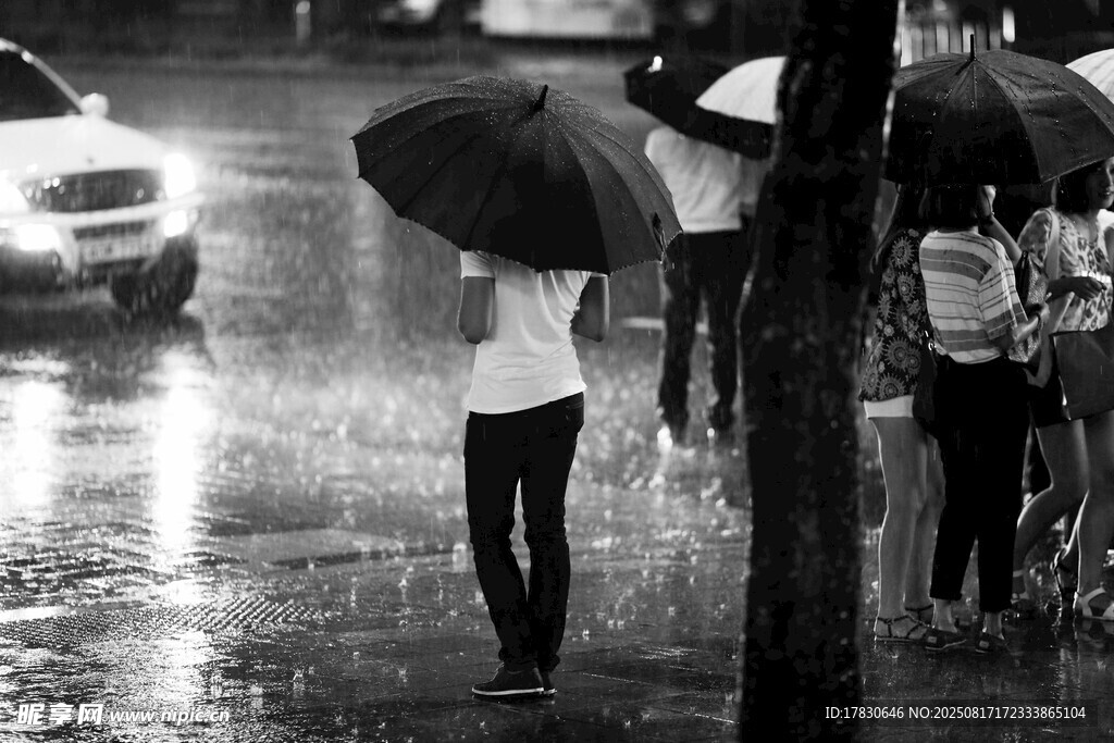雨中撑伞行人的黑白瞬间