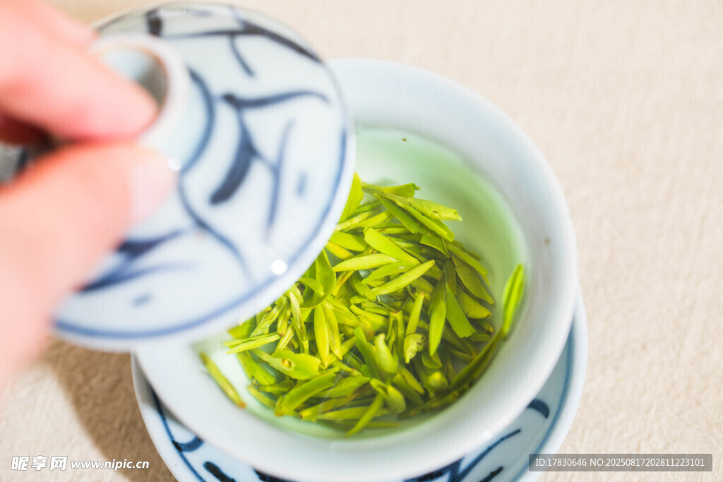 手掀盖赏杯中嫩绿新茶