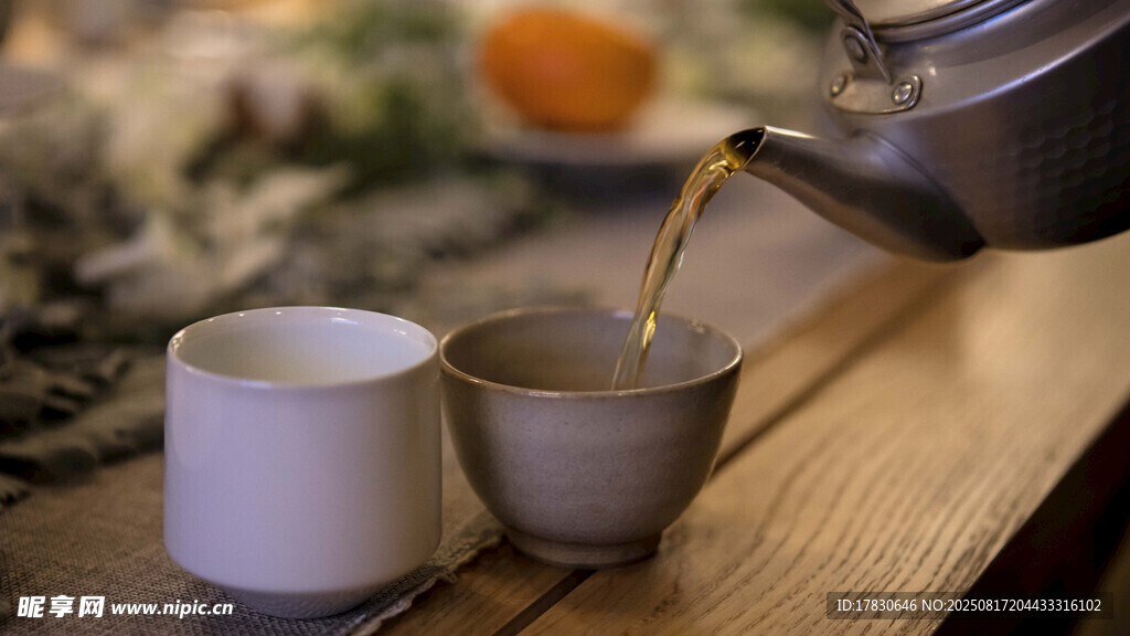 茶壶倒茶入杯温馨场景