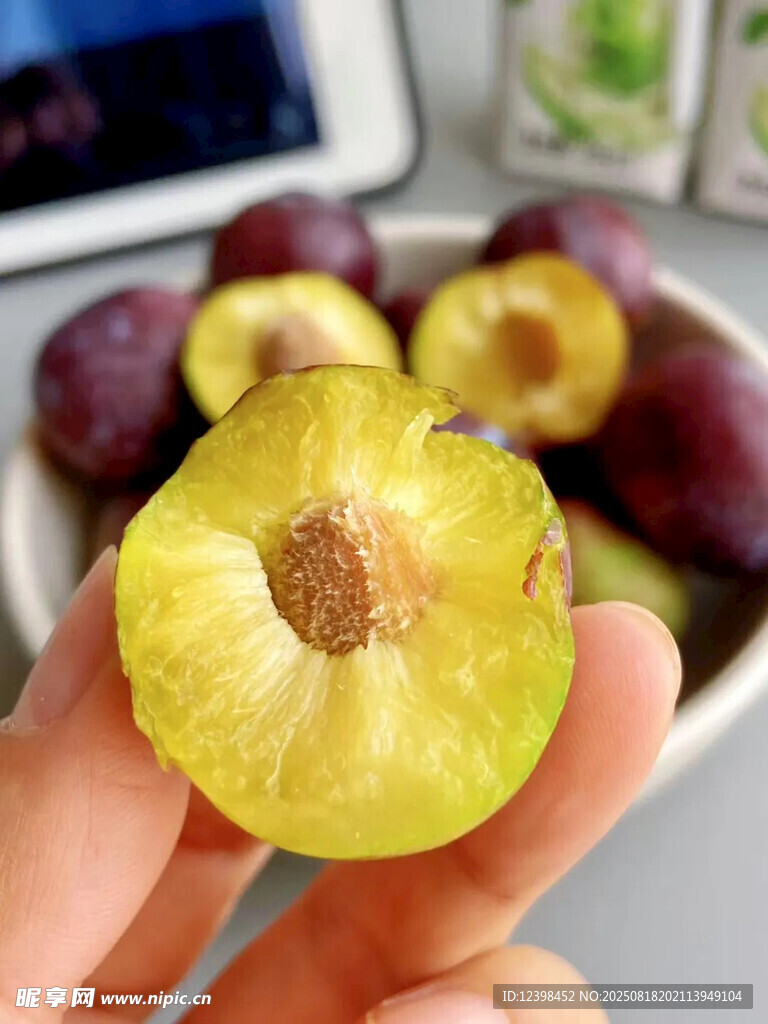 手捧切开的新鲜美味李子