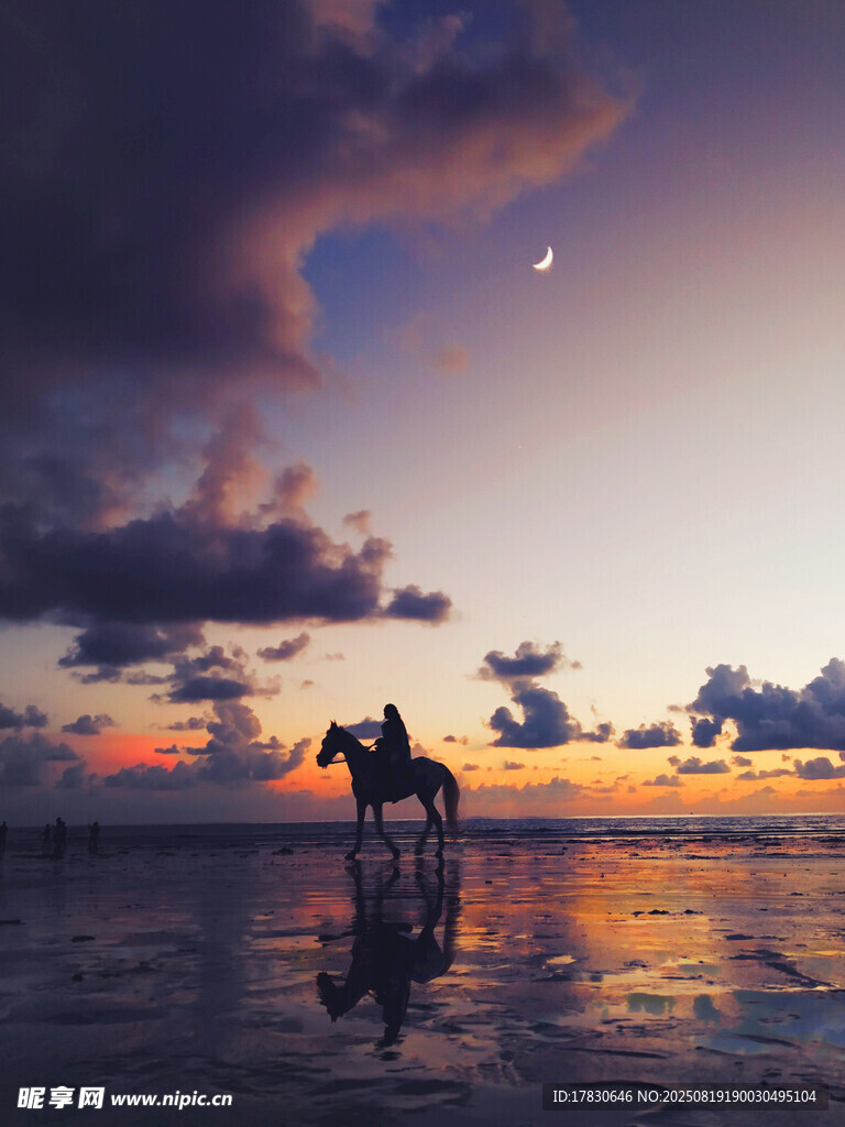 夕阳下海滩上的骑马景象