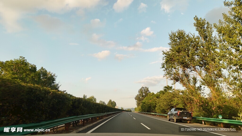 公路旁绿树蓝天行车景象