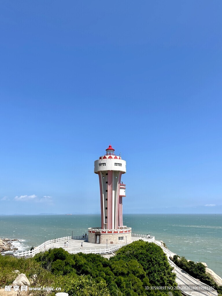 海边灯塔矗立在葱郁山丘