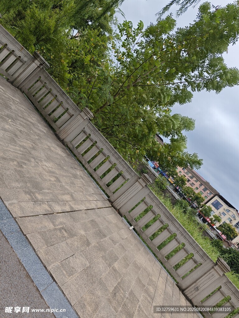 户外石栏杆旁绿树景观