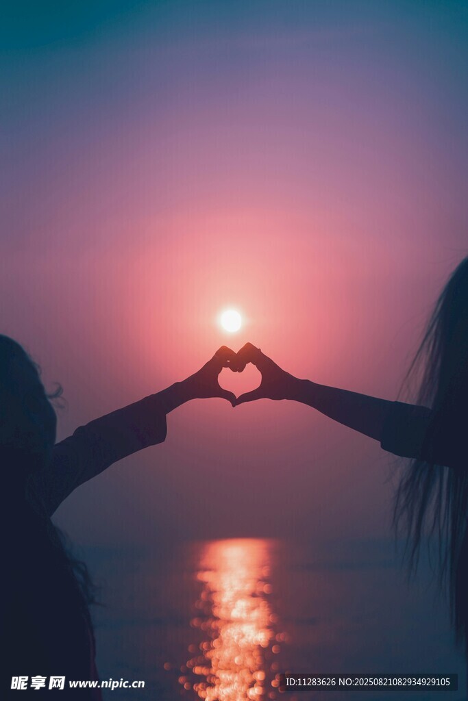 夕阳下情侣海边比心