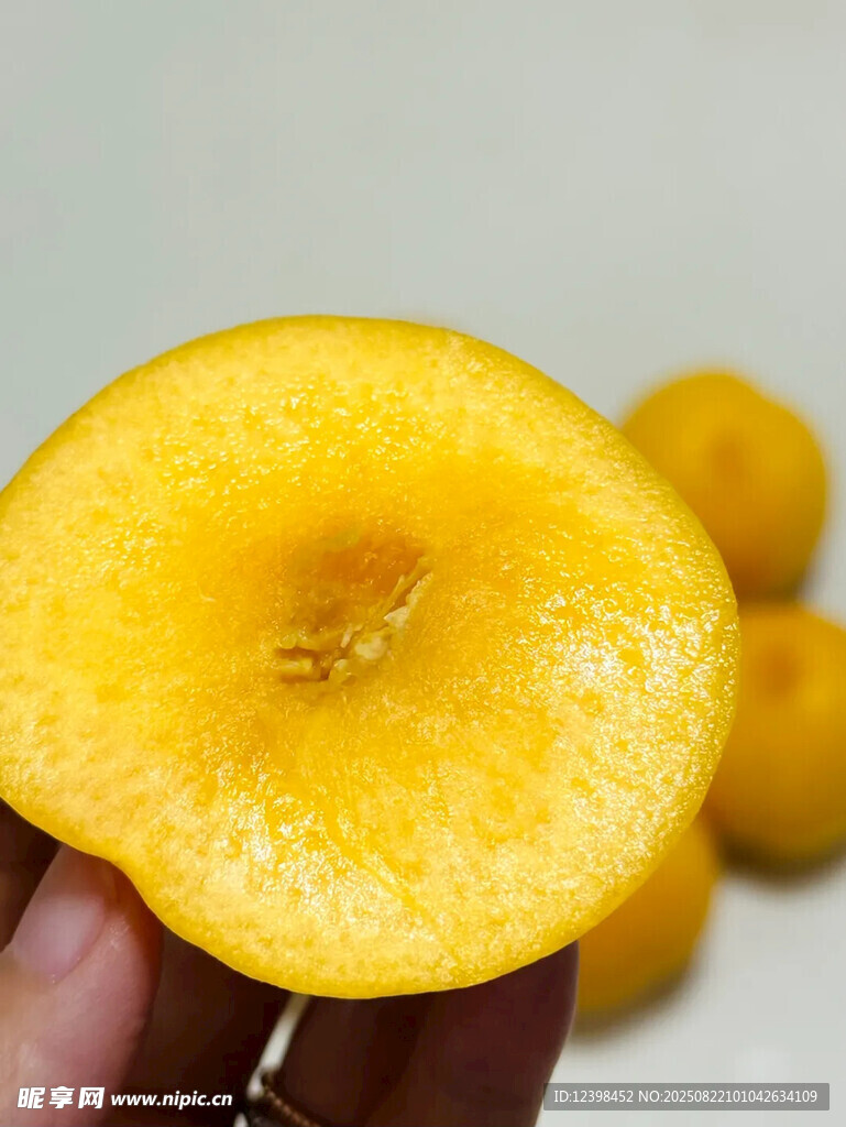 手捧切开的金黄桃子
