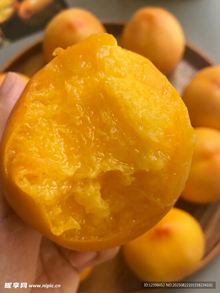 手捧金黄软糯黄桃果肉