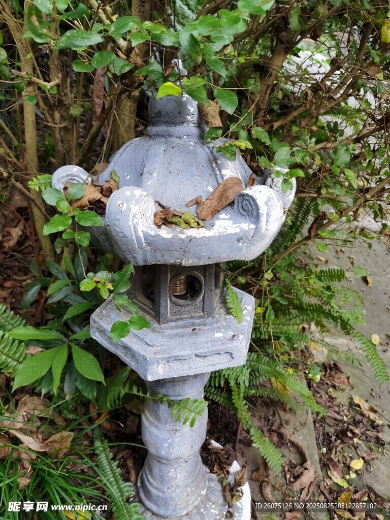 灰色石制灯笼隐于绿植间