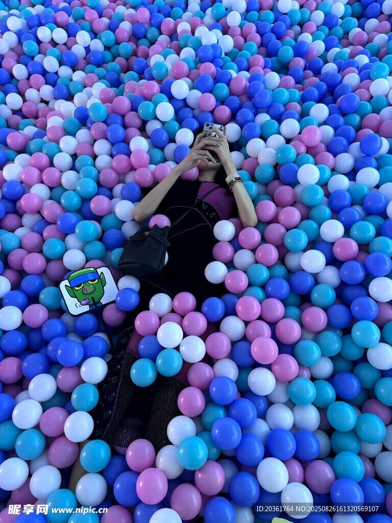 女孩置身多彩海洋球池