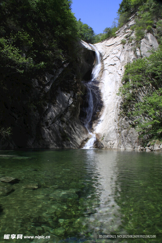 山间清澈瀑布下的碧绿潭水