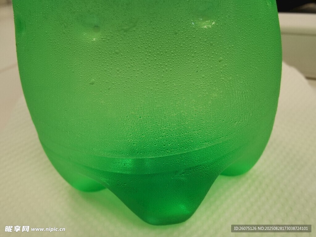 绿色塑料饮料瓶底部与水珠特写