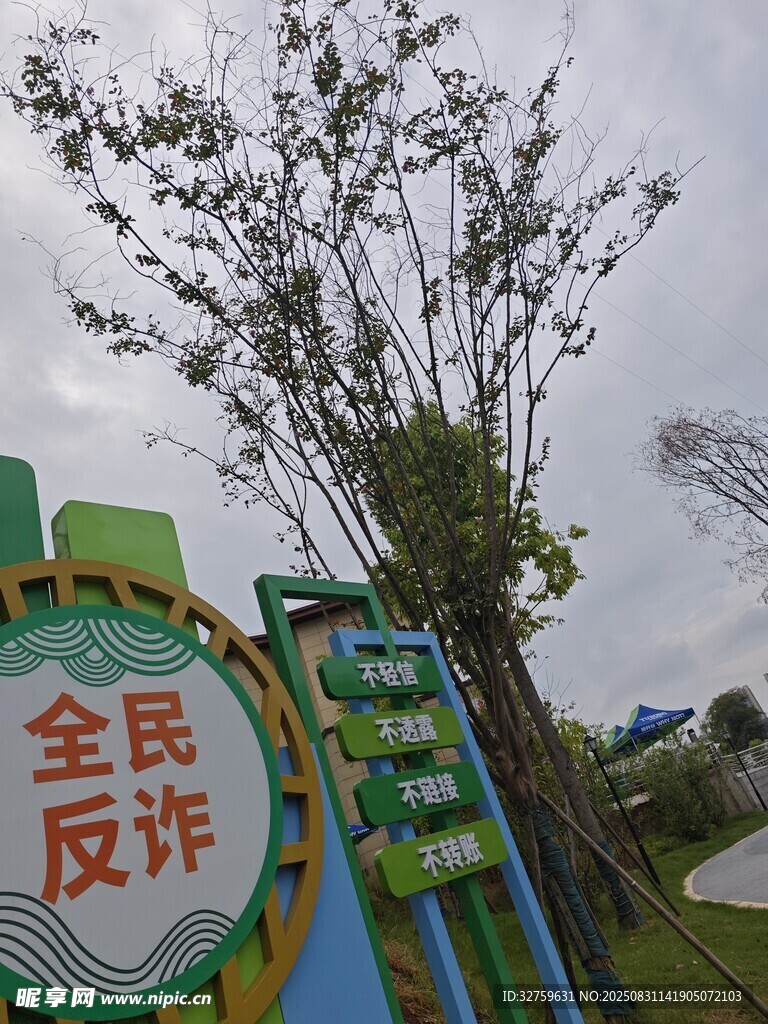全民反诈宣传牌与绿树
