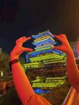 双手框景下的璀璨建筑夜景