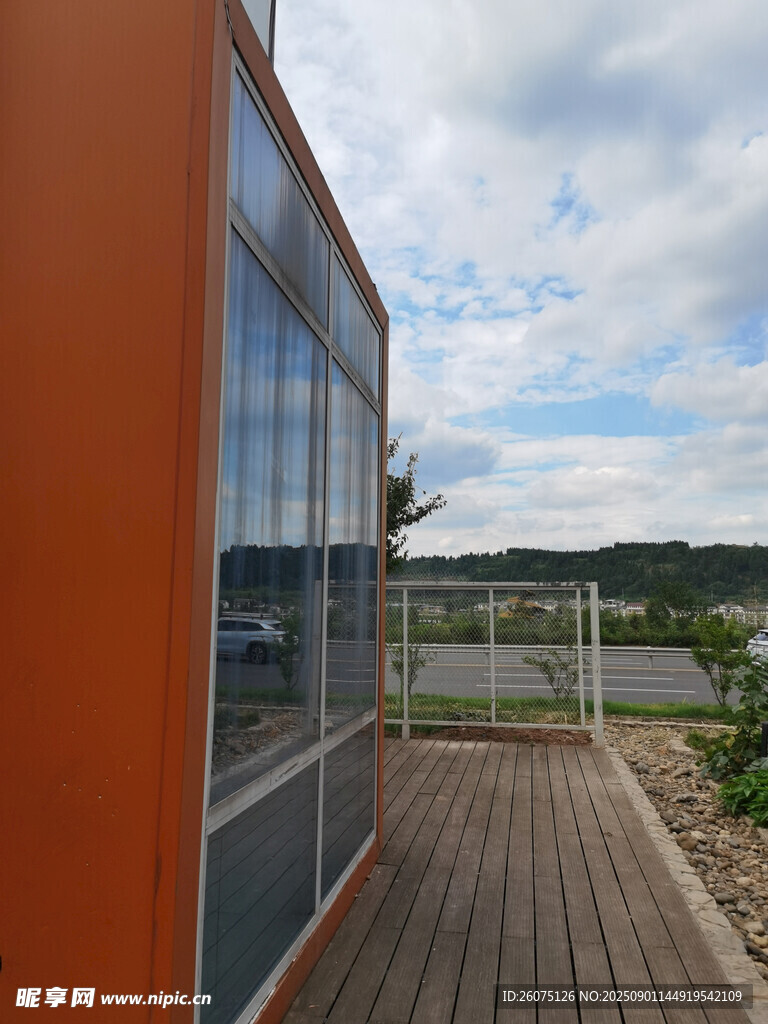 橙色小屋外的木质露台景观