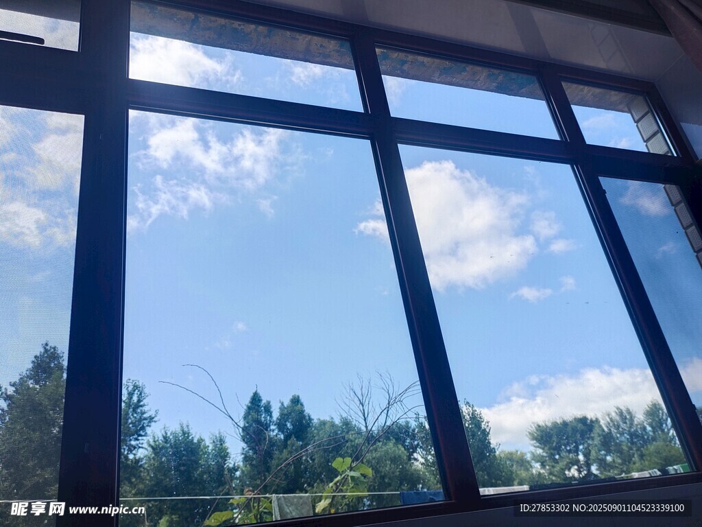 透过窗户望蓝天白云绿树