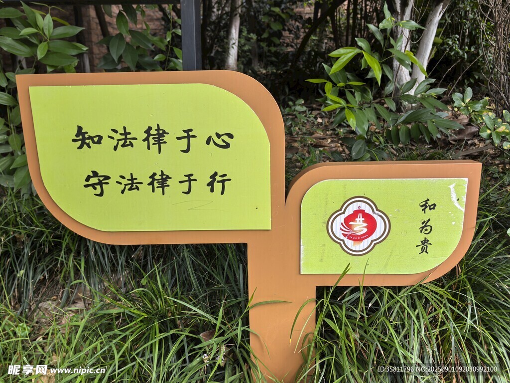 法律宣传牌立在绿植间