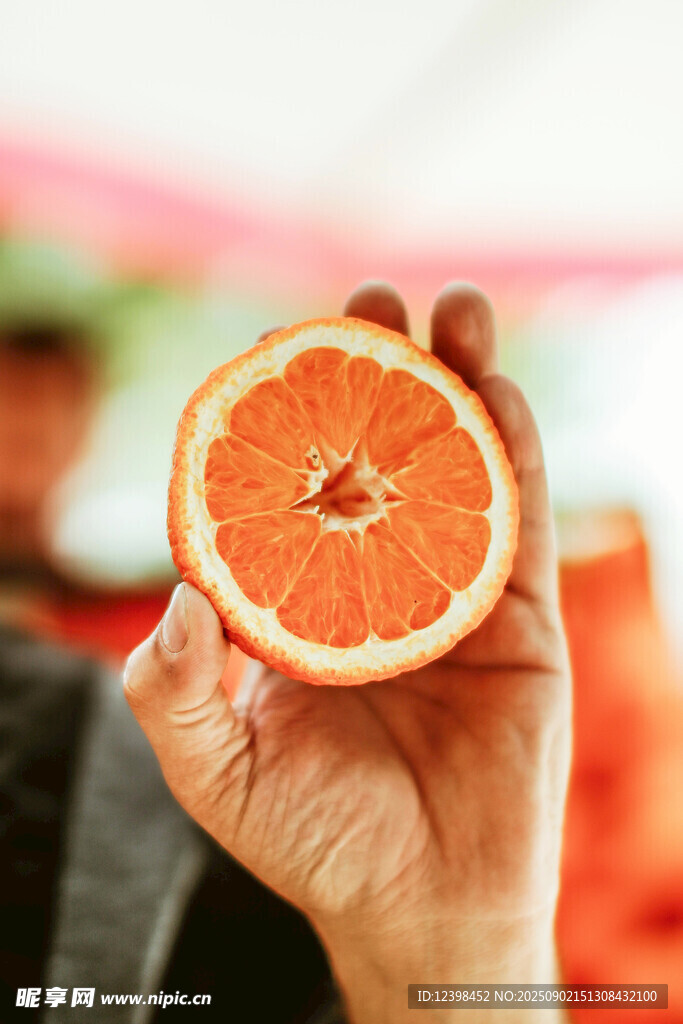 手持半颗鲜橙特写