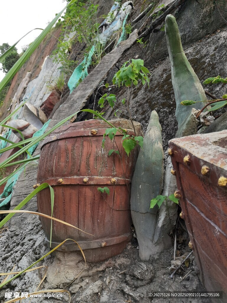山坡上的木桶雕塑与绿植景观