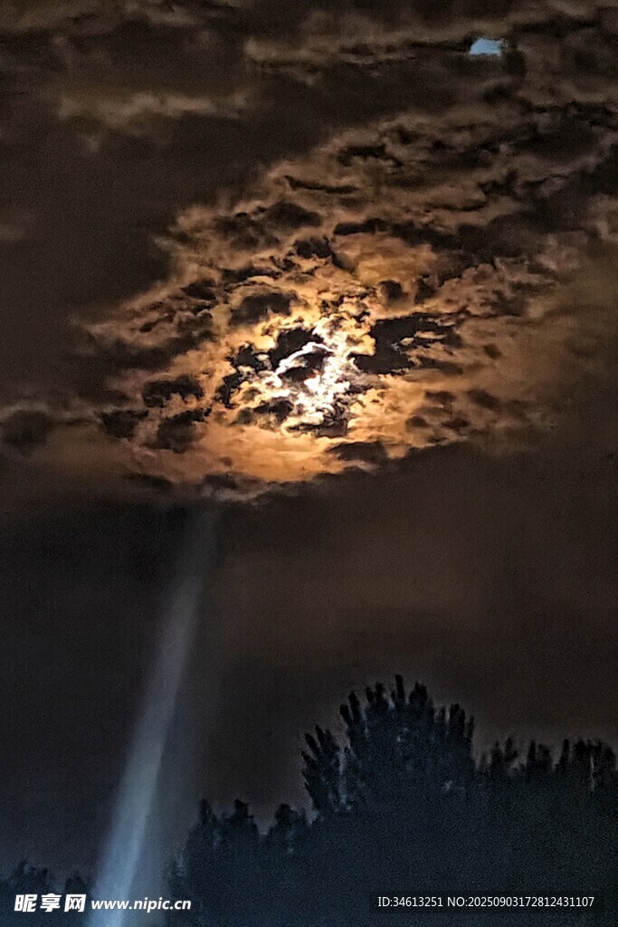 月光穿透云层洒向山林