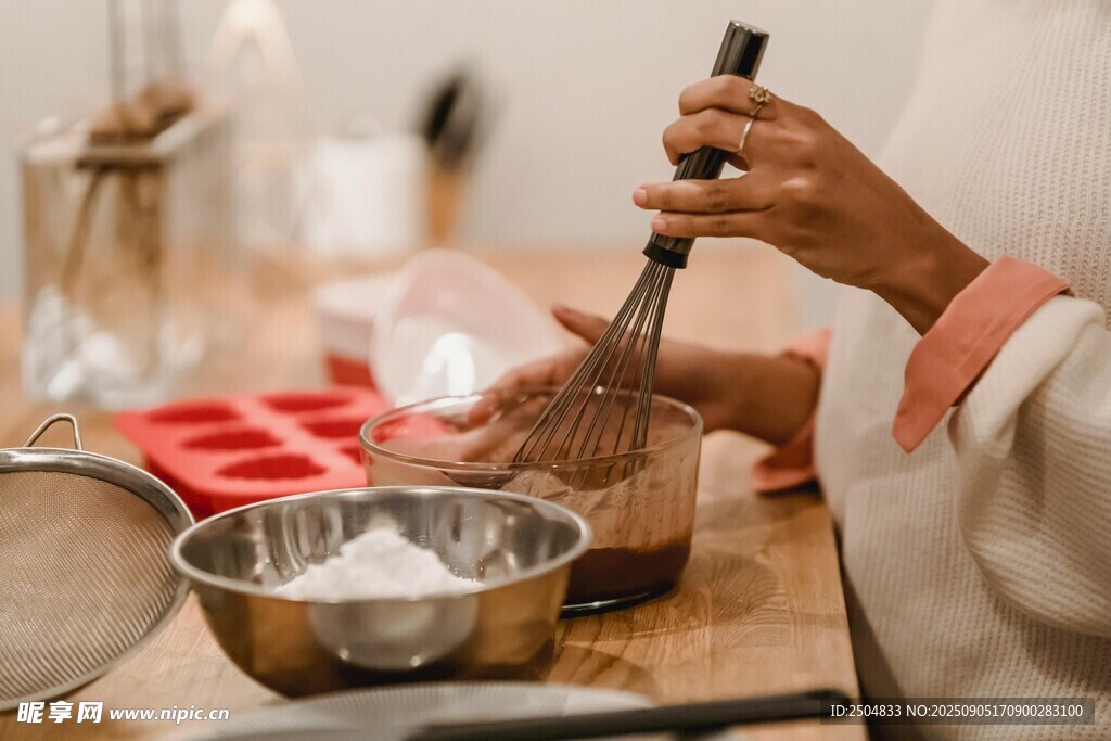 厨房中手持打蛋器的烹饪者