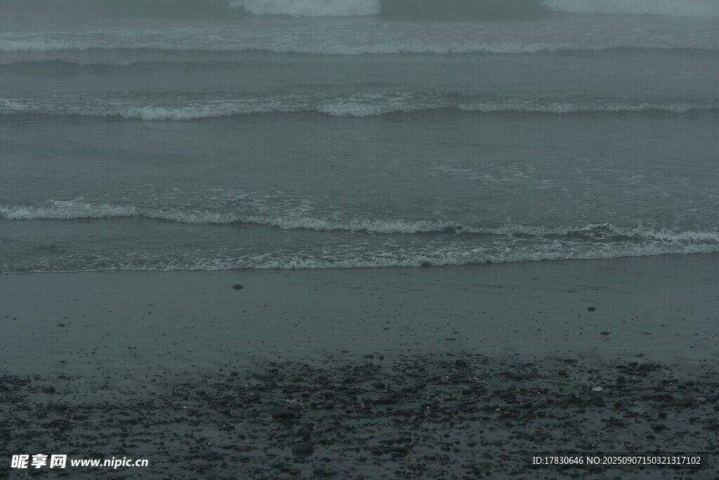海边暗色沙滩与海浪景象