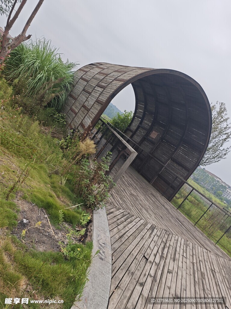 户外拱形建筑旁的木栈道