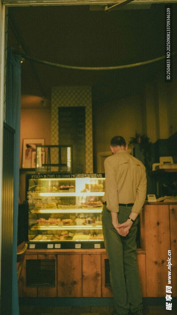 男子背对镜头站在陈列架前