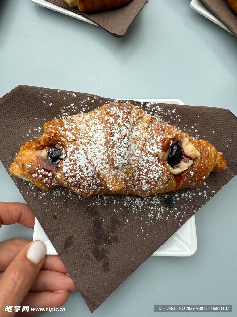 手持糖粉撒面的美味糕点