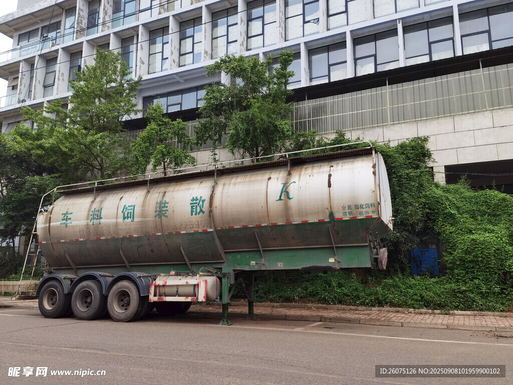 废弃卡车停于绿植环绕建筑旁