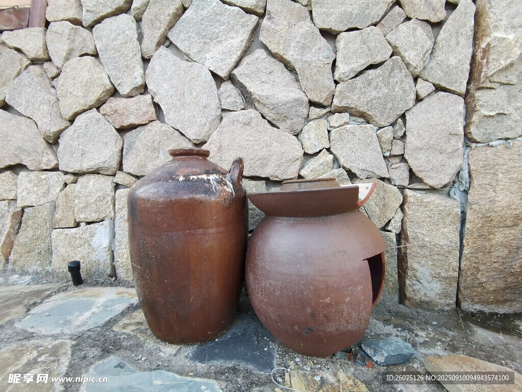 石墙旁的古朴陶制容器