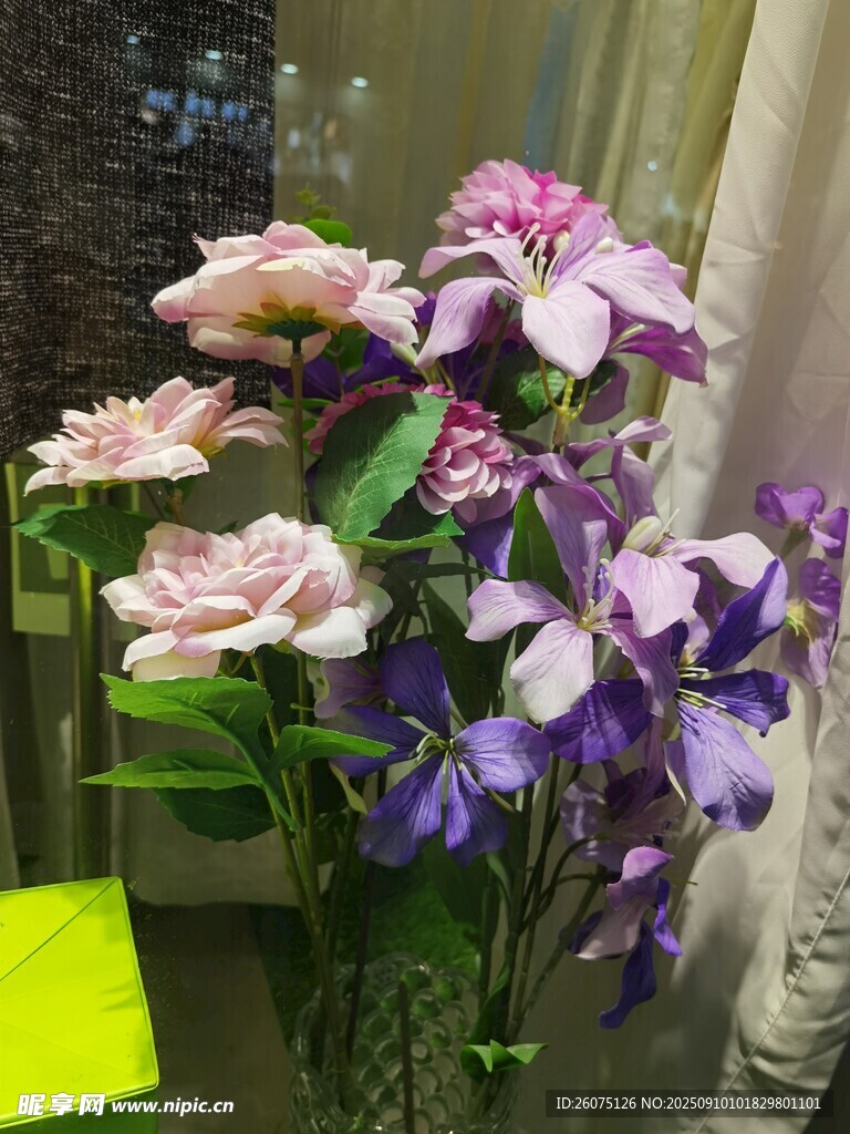 多彩仿真花卉插于透明花瓶中