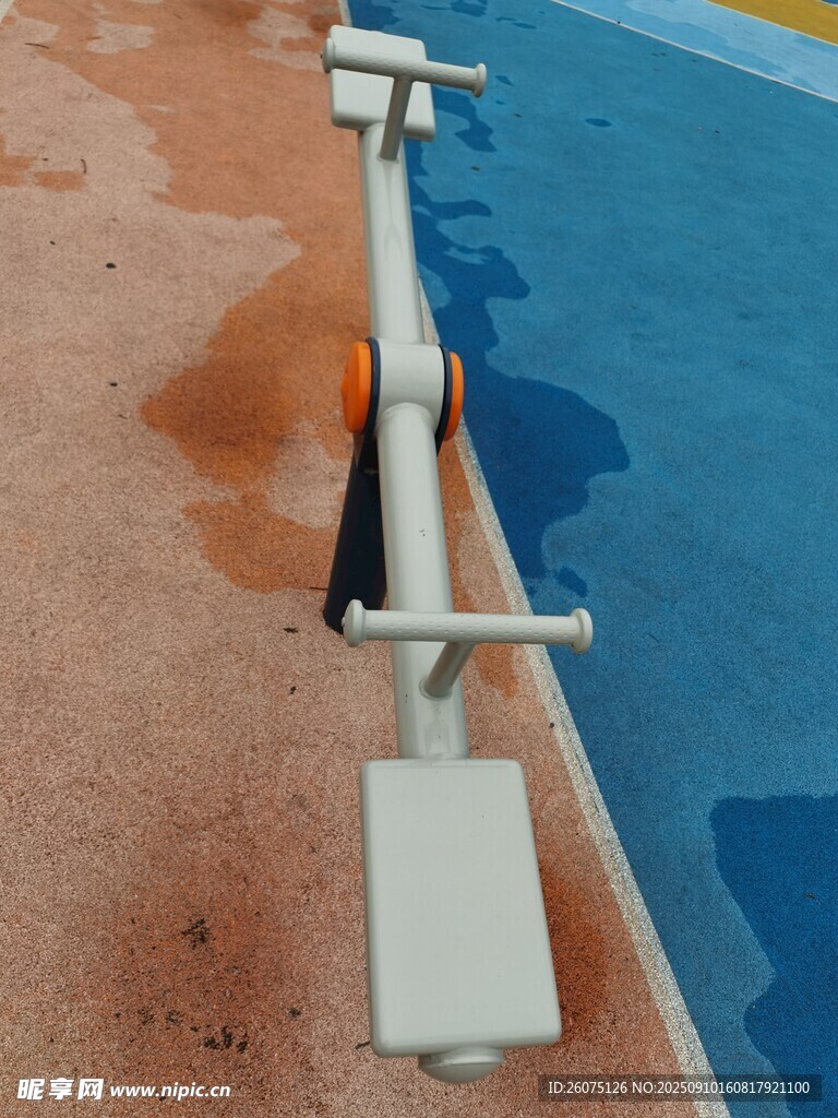 雨后运动场地的金属跷跷板