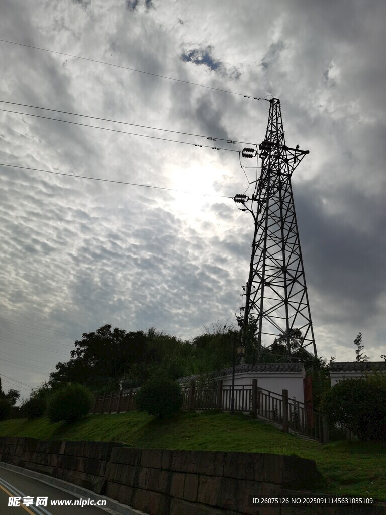 高耸铁塔立于多云天空下