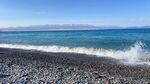 赛里木湖黑砾石海滩上的海浪美景