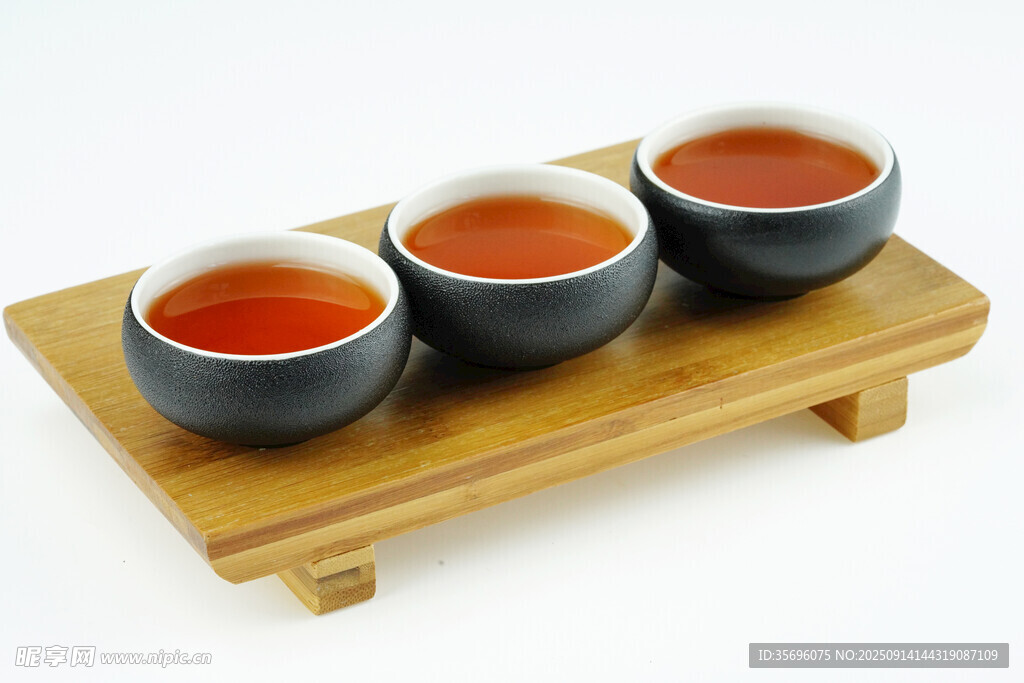 三杯红茶置于木制茶托上
