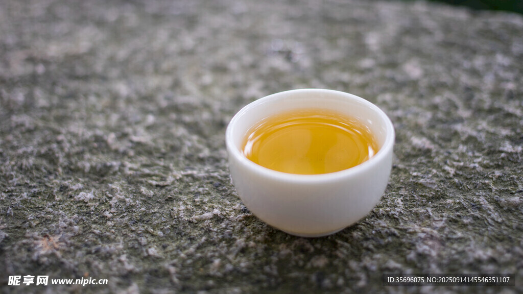 石上白杯盛金黄液体