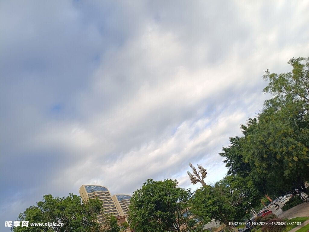 蓝天白云下的绿树与建筑