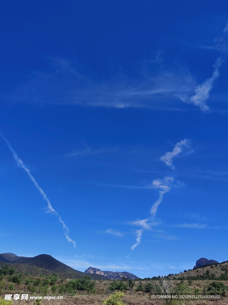 蓝天之下的山间航迹云