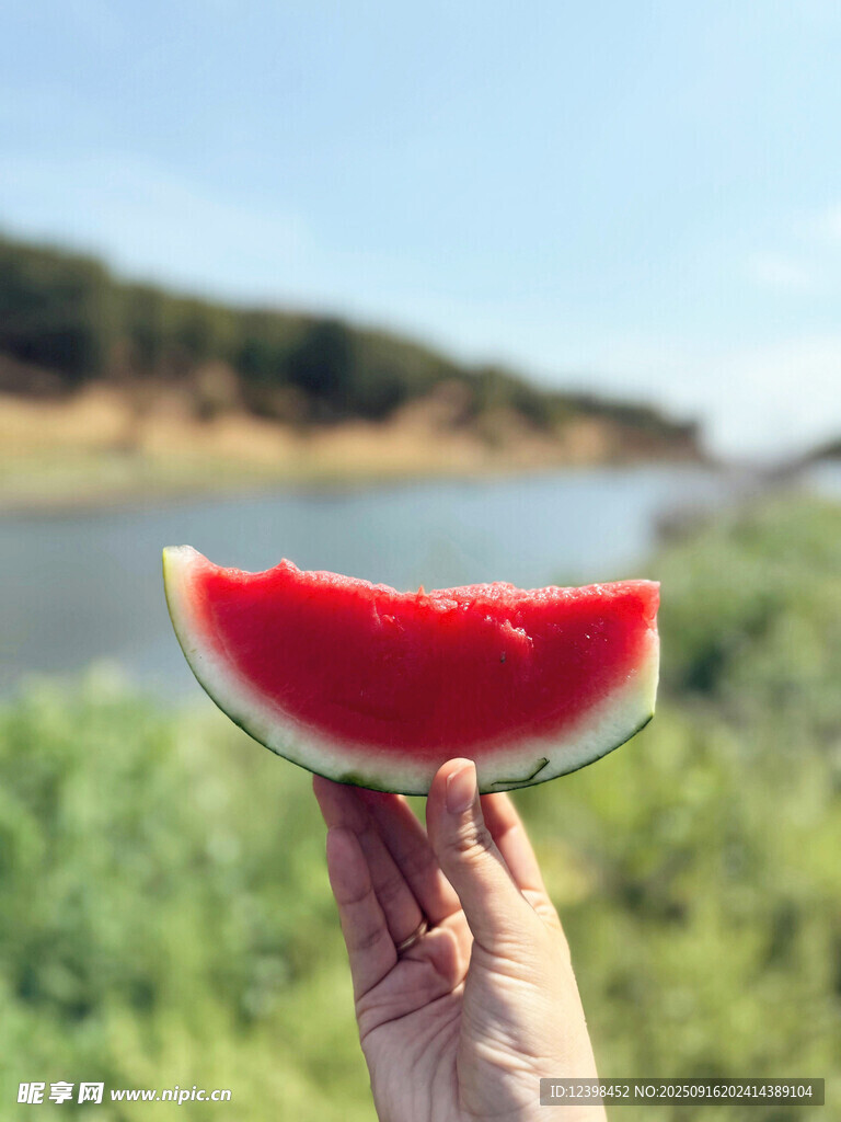 手举鲜红西瓜于河畔