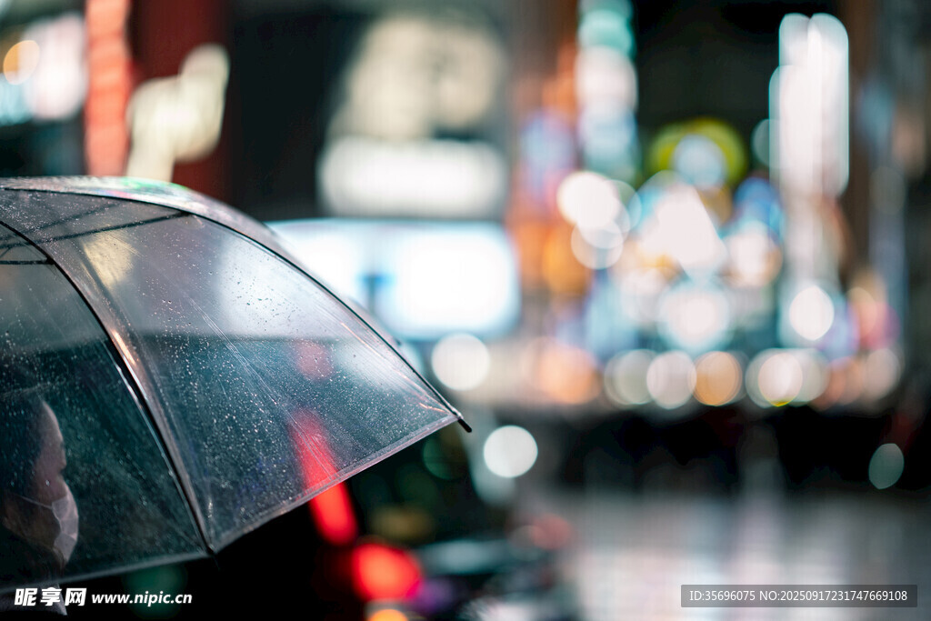 雨中撑伞的模糊城市景象