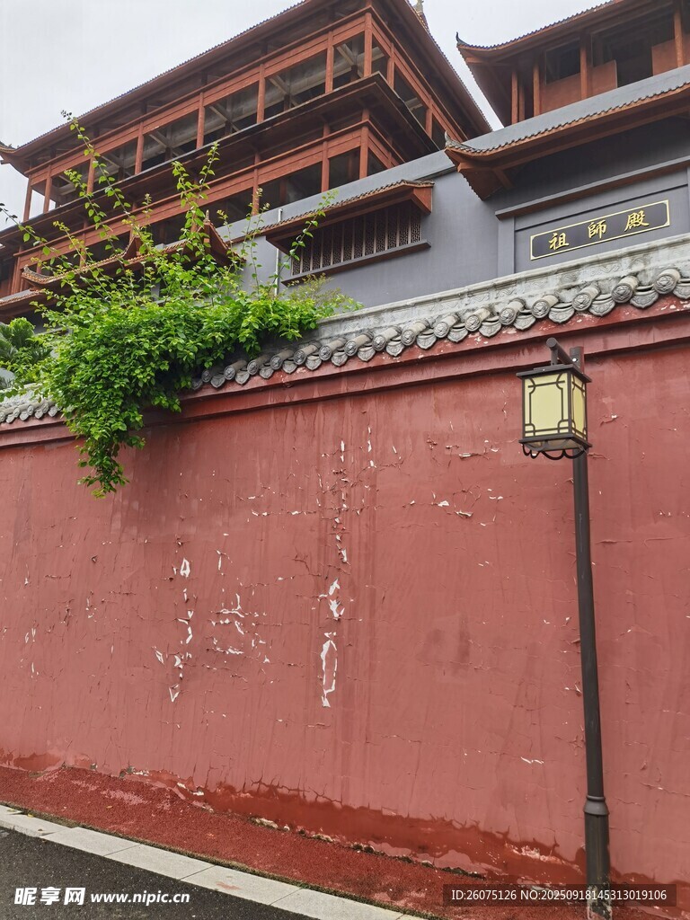 红墙绿植旁的中式古建筑