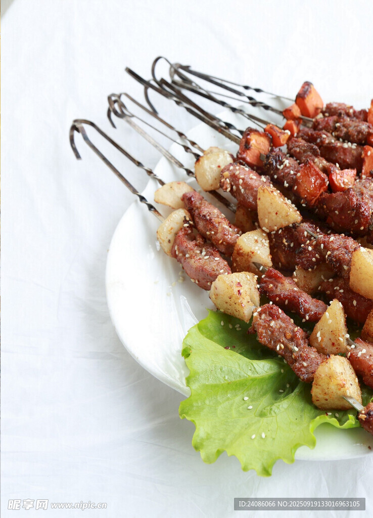 美味烤肉串摆于生菜之上