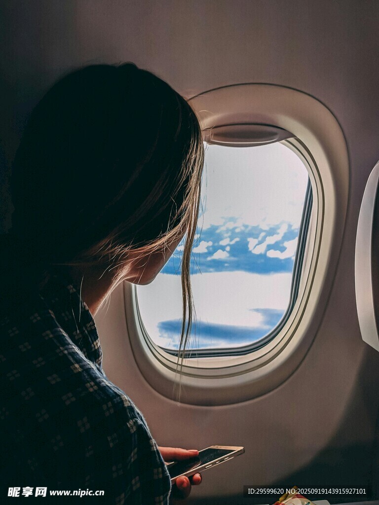 飞机上女子透过窗看风景