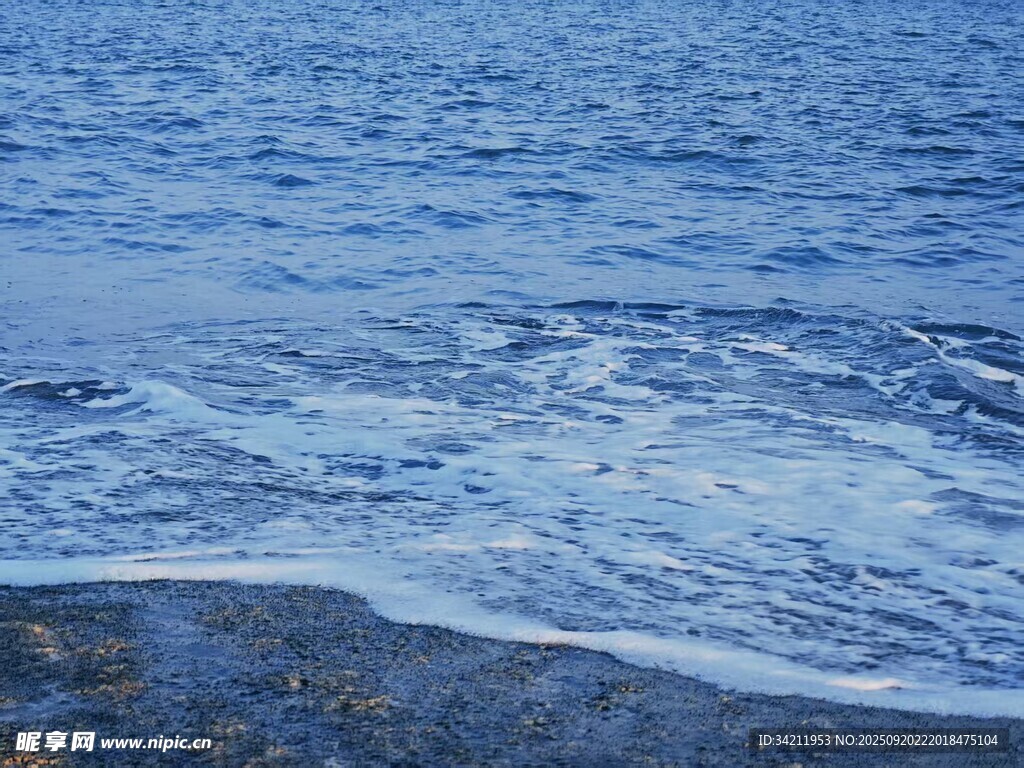 海边浪花拍打沙滩景象