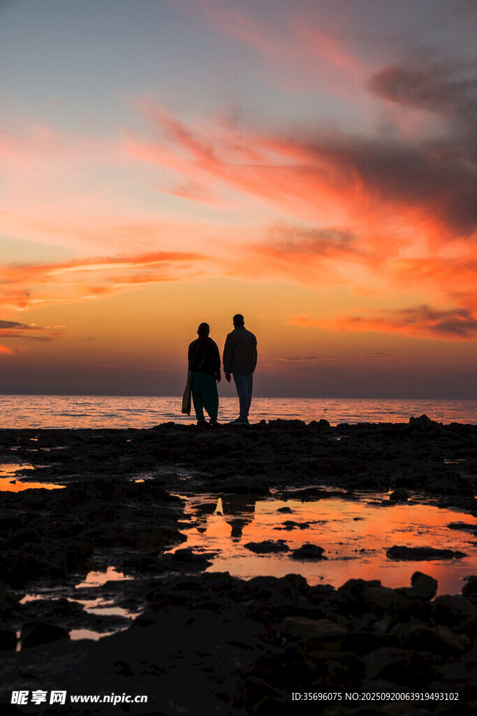 夕阳下三人海边浪漫剪影