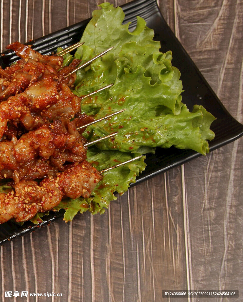美味烤肉串摆于翠绿生菜上