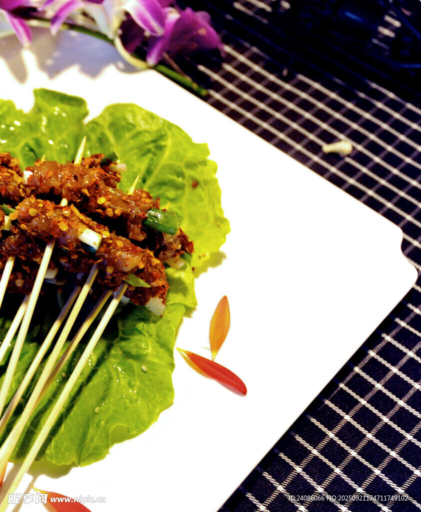 美味烤肉串摆于绿叶盘上