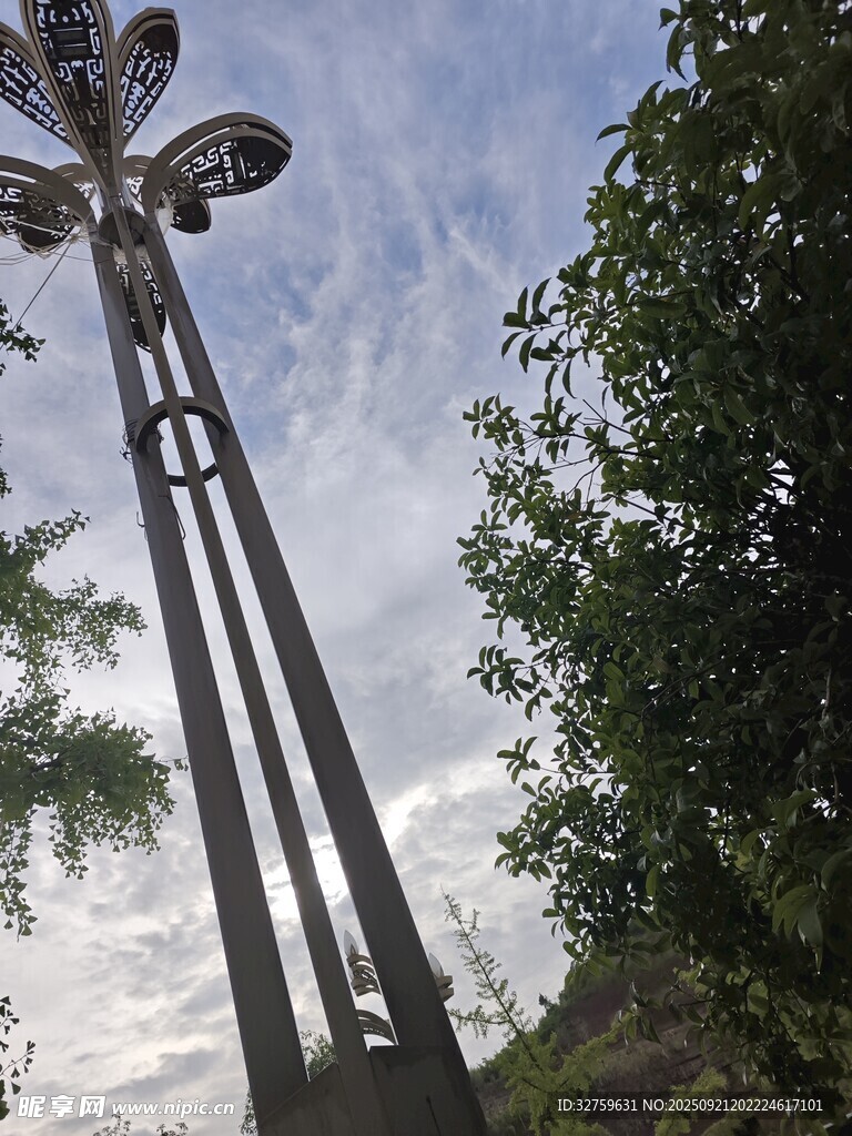 高耸金属雕塑与绿植天空
