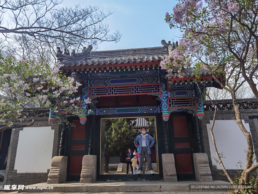 中式古门楼前的游客