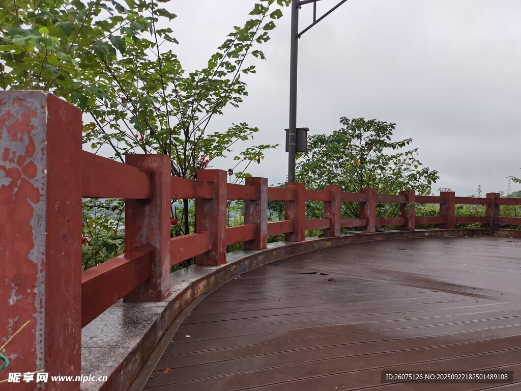 雨中红栏杆与湿润路面